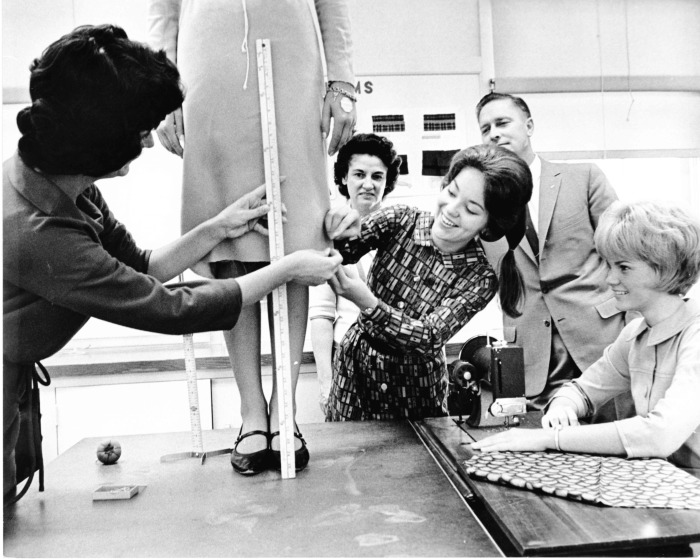 Van Nuys, CA - Skirt hemming at Van Nuys High School - Demonstrations put on by students for Parents Night at P.T.A. - In the background are Mr. and Mrs. Lou Richey, Michele Chole hemming dress, and Debbie Brodrick at the sewing machine