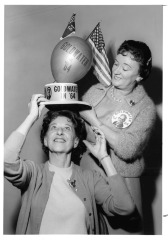 Goldwater Headquarters - L.A. County Chairman, Mrs. John D. Bowler, Jr. places hat on Mrs. F. Roy Ingraham, North Hollywood Chairman