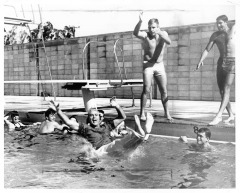 Northridge, CA - Valley State College (CSUN) - New pool opens with student Joel Schaeffer tossing swimming coach Byrne Fernentino (?) into the pool