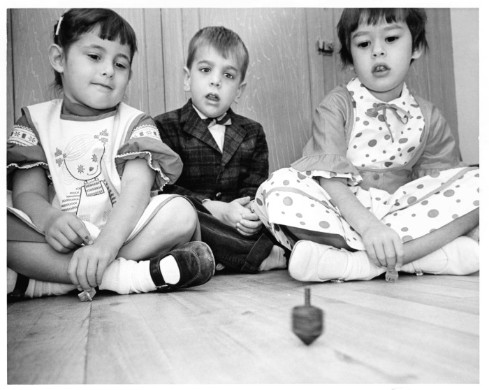 Valley Beth Shalom - Nursery school children play dreidel. From left to right are Sarah Brawn, Alan Sinder, and Donna Weinstein